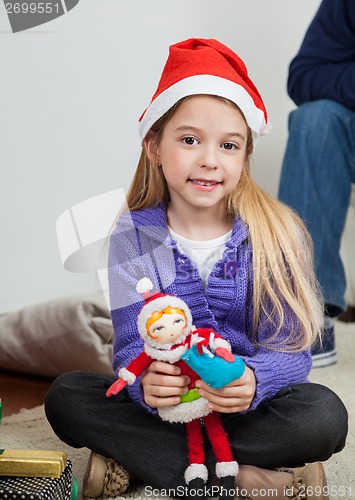 Image of Girl In Santa Hat Holding Toy