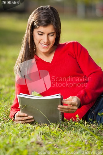 Image of Woman Reading Book On Grass At University Campus