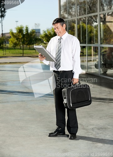 Image of Male Professor Reading Book At University Campus