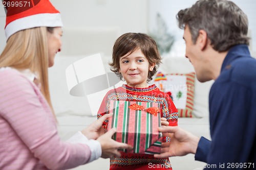 Image of Boy Receiving Christmas Gift From Parents