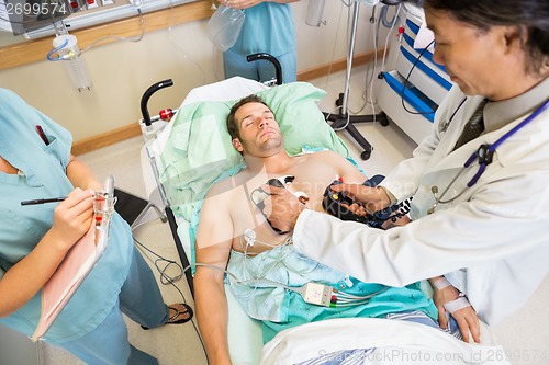 Image of Doctor Defibrillating Male Patient In Hospital