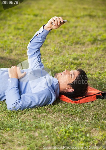 Image of Student Reading Text Message On Mobilephone At College Campus