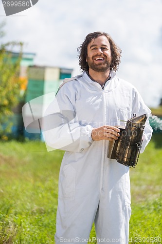 Image of Happy Male Beekeeper Holding Smoker