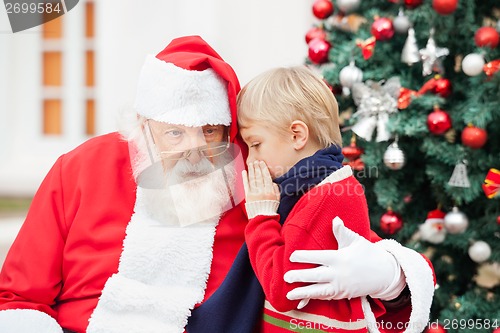 Image of Boy Whispering In Santa Claus's Ear