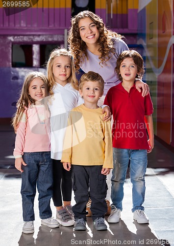 Image of Cute Little Children With Teacher In Kindergarten