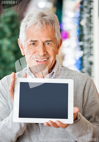 Image of Happy Man Displaying Digital Tablet In Christmas Store