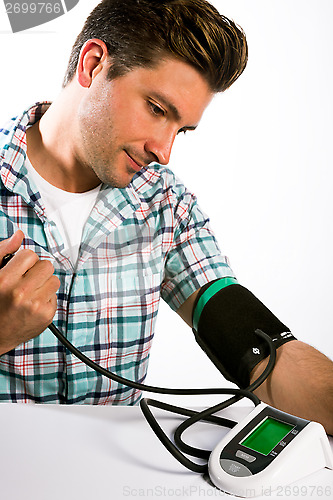 Image of Man taking his blood pressure reading.