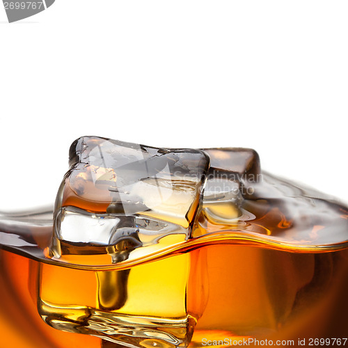 Image of Close up splash of whiskey with ice isolated on white