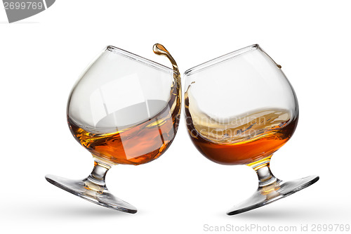 Image of Splash of cognac in two glasses isolated on white background