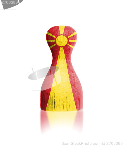 Image of Wooden pawn with a painting of a flag