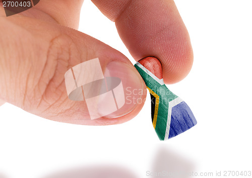 Image of Hand holding wooden pawn, flag painting, selective focus