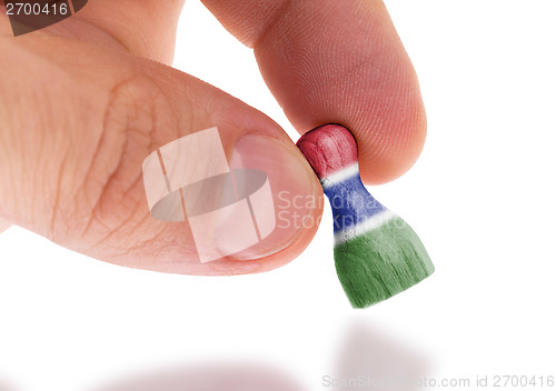 Image of Hand holding wooden pawn, flag painting, selective focus