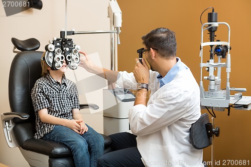 Image of Optometrist Examining Preadolescent Boy's Eyes