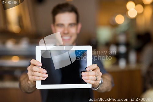 Image of Cafe Owner Showing Digital Tablet