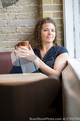 Image of Woman Sitting By Window In Cafe