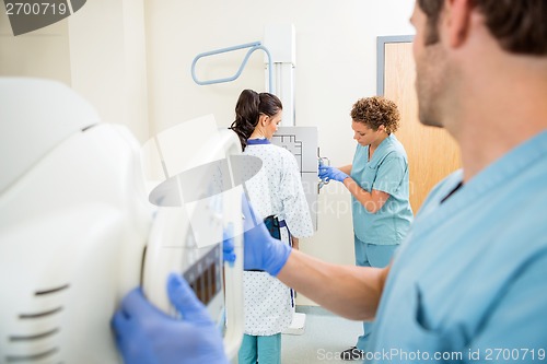 Image of Nurses Adjusting Chest Xray Machines For Patient
