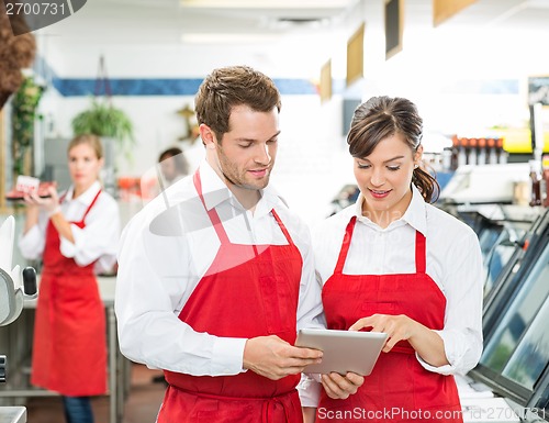 Image of Butchers Using Digital Tablet At Store