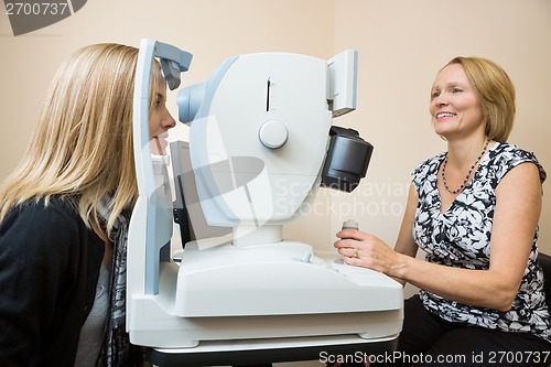 Image of Optician Examining Patient's Eye With Retina Camera