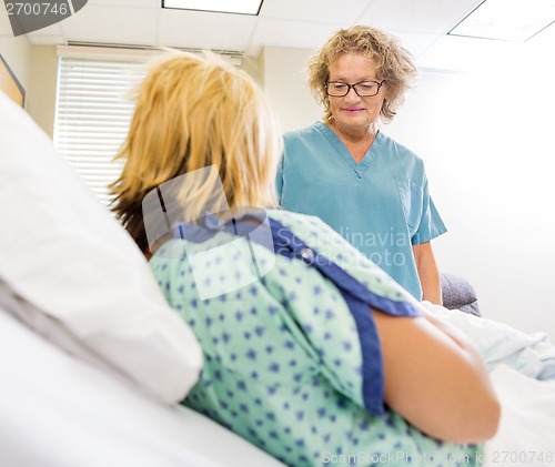 Image of Nurse Looking At Newborn Babygirl With Mother In Hospital