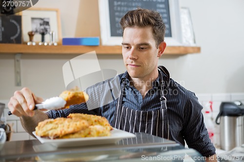 Image of Cafe Owner Serving Sweet Food