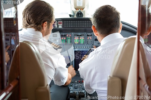 Image of Pilot And Copilot In Private Jet Cockpit