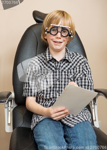 Image of Boy With Trial Frame Holding Test Chart At Optician
