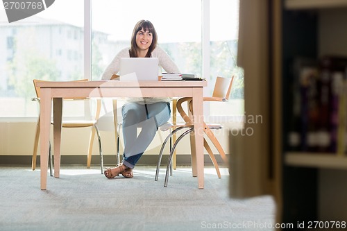 Image of Student With Laptop Looking Away In Library