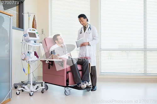 Image of Doctor Showing Digital Tablet To Patient In Chemo Room