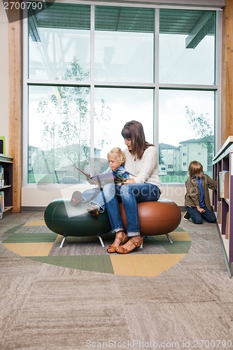 Image of Boy With Teacher Reading Book In Library