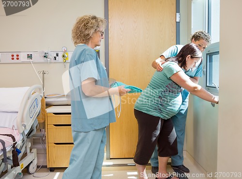Image of Nurse Carrying Hospital Gown For Pregnant Woman