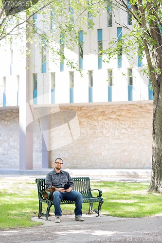 Image of University Student Sitting On Bench At Campus