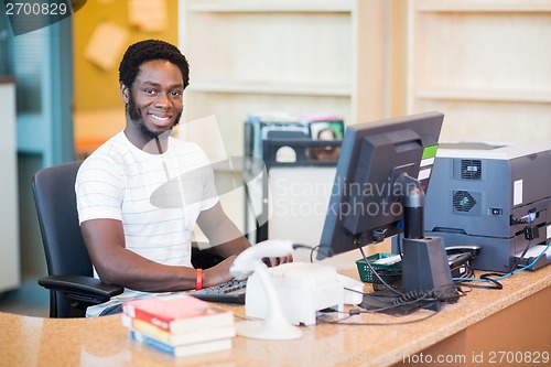 Image of Male Librarian Working At Desk