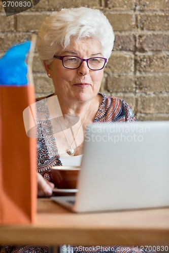 Image of Customer Using Laptop In Cafe