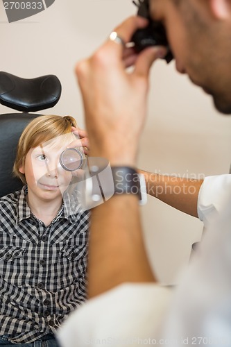 Image of Boy Looking At Optician Examining His Eyes Through Lens