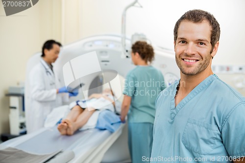 Image of Nurse With Colleague And Doctor Preparing Patient For CT Scan