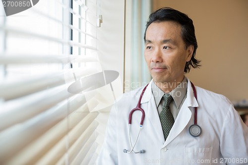 Image of Thoughtful Doctor Looking Out Through Window