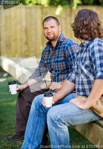 Image of Confident Worker Holding Disposable Cup While Sitting With Cowor
