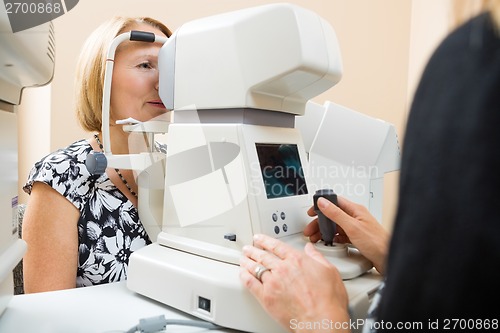 Image of Optician Examining Patient's Eye With Tonometer