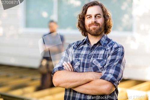 Image of Confident Carpenter With Arms Crossed At Construction Site