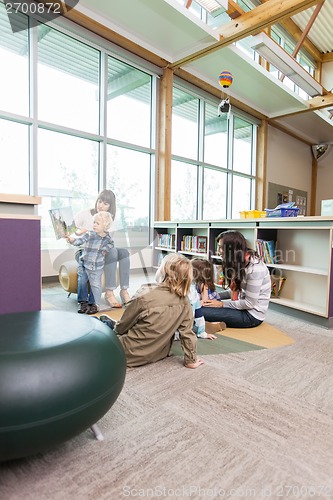 Image of Teachers And Primary Students In Library