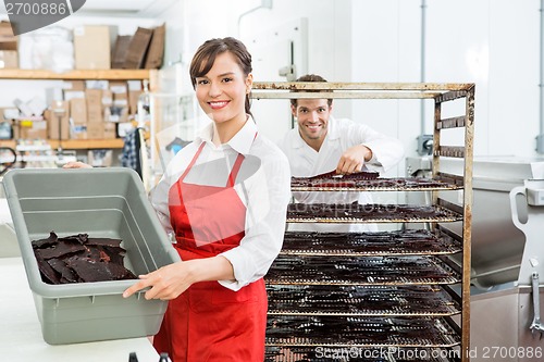 Image of Beautiful Worker Showing Beef Jerky In Basket At Shop