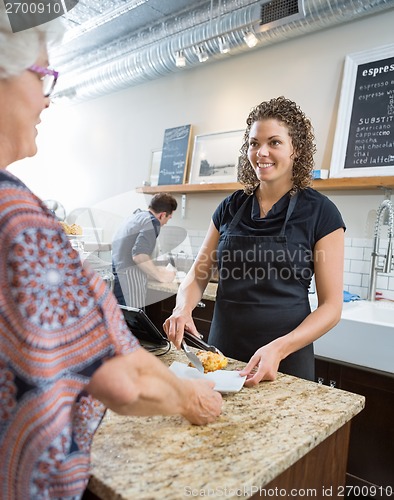 Image of Cafe Owner Serving Sweet Food To Senior Woman