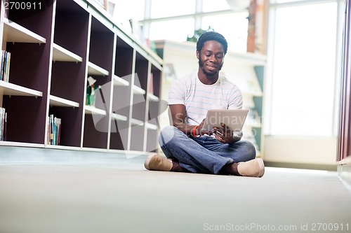 Image of Male Student Using Digital Tablet In Library