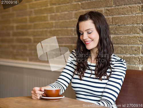 Image of Attractive Woman Looking At Coffee Cup In Cafe