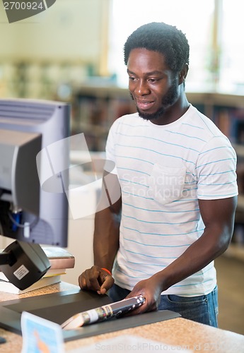 Image of Librarian Working At Counter In Bookstore