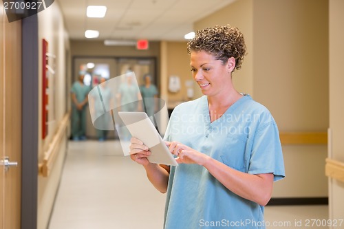 Image of Doctor Using Digital Tablet In Hospital Corridor