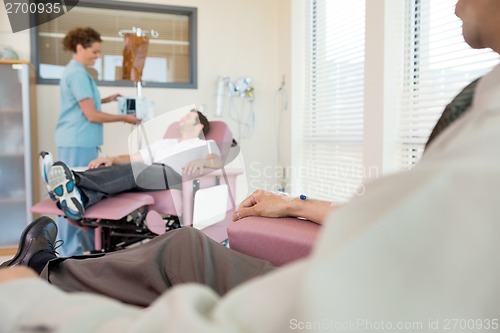 Image of Female Nurse Adjusting IV Machine For Patient