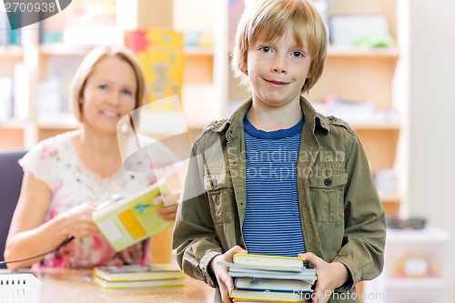 Image of Boy Checking Out Books From Library