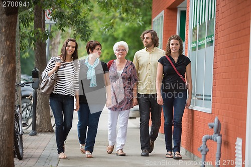 Image of Friends Walking Together On Pavement