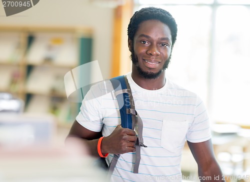 Image of Student Standing By Bookshelf In Library